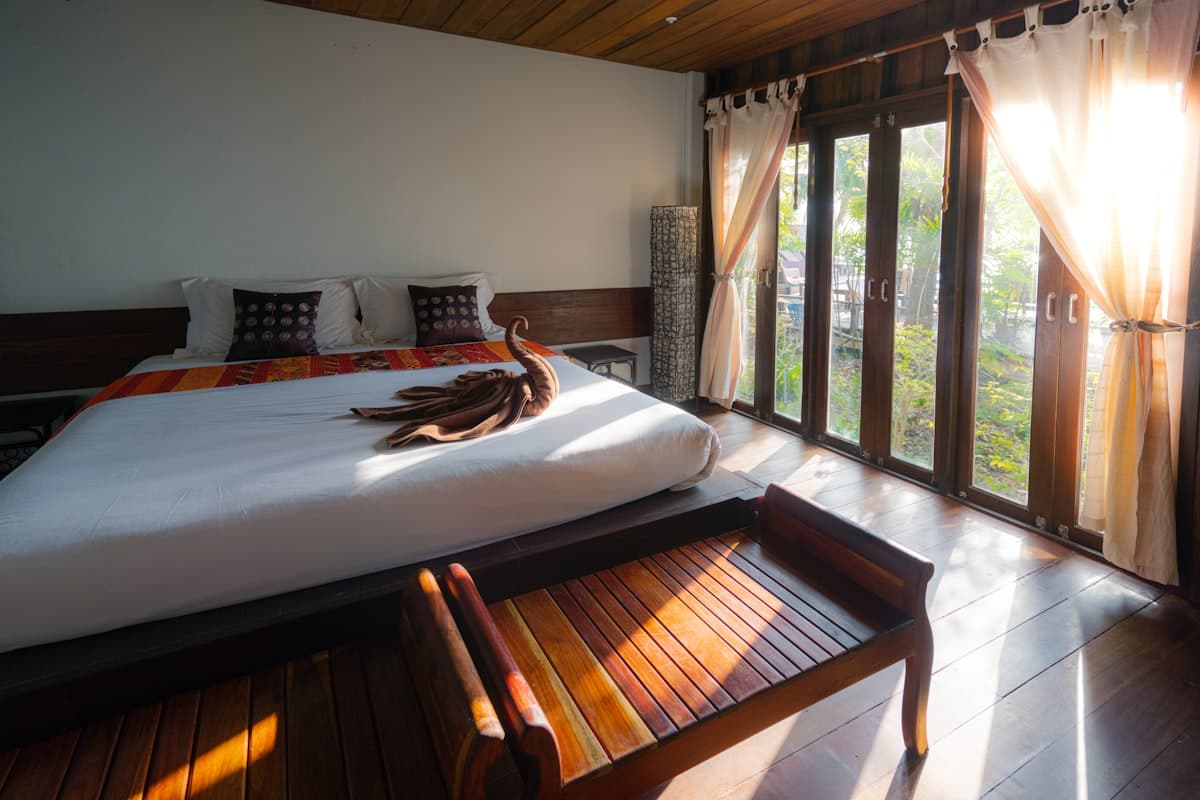 Sunlit suite with warm wooden interiors and crisp white bedding