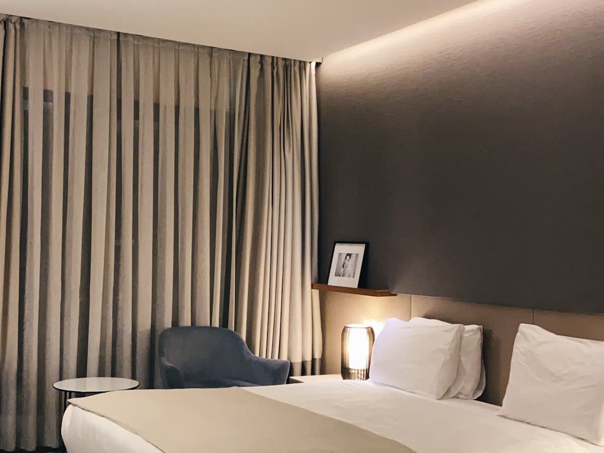 Luxury hotel bed with plush supportive pillows in soft evening light